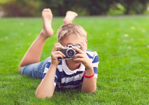 Happy smiling little boy with retro vintage camera photo