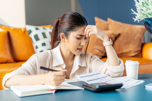 Upset asian woman sit at desk do accounting job or manage personal finances, reviewing bills feels upset due huge taxes, sum need to pay, experiences lack of money, crisis, bankruptcy concept photo