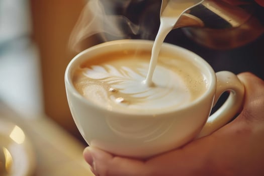 Young cheerful barista steams milk pouring preparing coffee morning busy cafe owner coffeeshop professional espresso latte art cappuccino cup mug caffeine standing counter customers photo