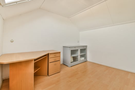 An empty room with a desk and a window photo