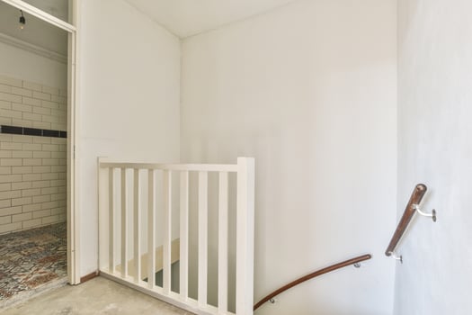 A stairway with a white railing and a door photo