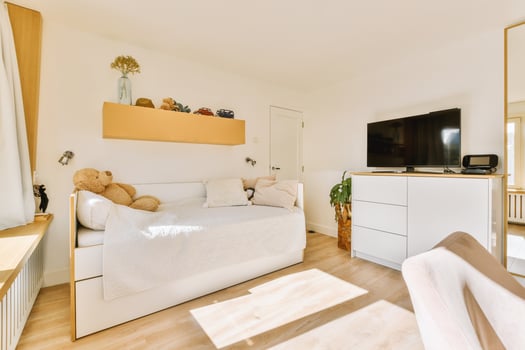 A bedroom with a bed, a tv and a desk photo