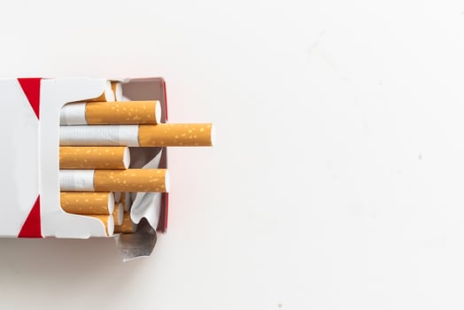 Open blue pack of cigarettes isolated on white background. Box of cigarettes closeup. photo