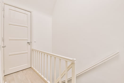 White door and wooden stairs in a room photo