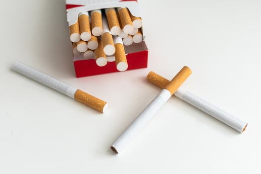 Pack full of filtered cigarettes on white isolated background. photo