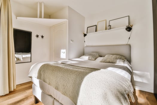 A bedroom with a bed and a mirror photo