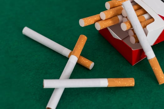 Cigarettes fall on a green background. photo