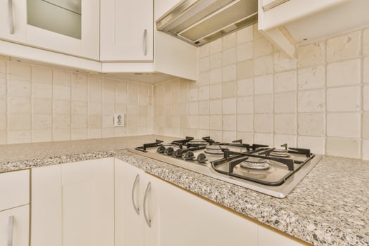 A kitchen with a stove top and a sink photo