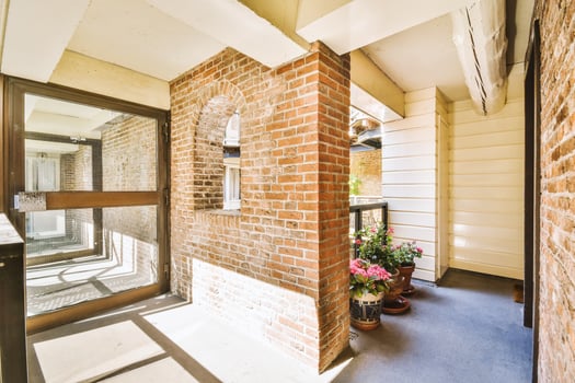 A brick wall and door leading to a balcony photo