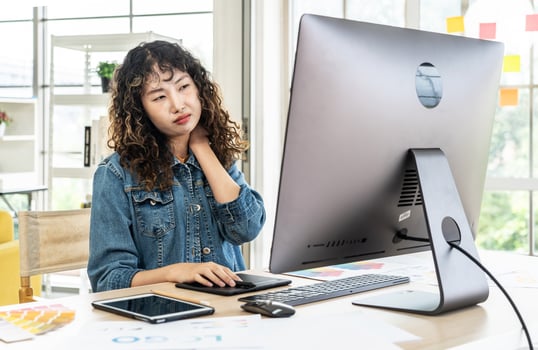 Tired fatigued asian girl feel neck discomfort with computer work in office, Young Asia girl development programmer overworked tired painful shoulder neck muscle from office syndrome photo