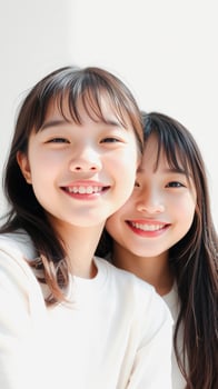 Two Asian Women Smiling and Looking at Camera photo