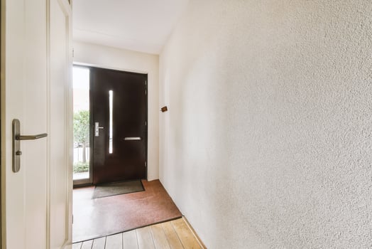 A hallway with a door and a wooden floor photo