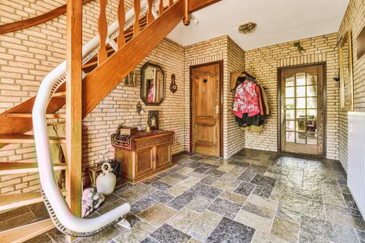 A hallway with a brick wall and stairs photo
