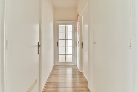 A hallway with white walls and wooden floors photo