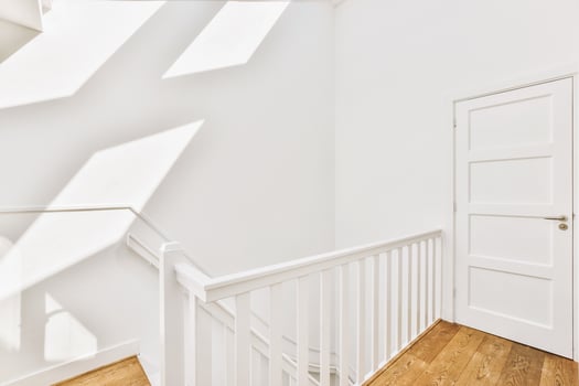 White staircase with wooden floor and white door photo