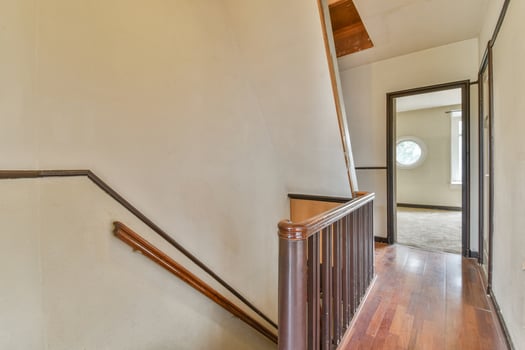 A hallway with a wooden railing and a door photo