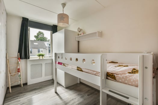 A small bedroom with a bunk bed and a window photo