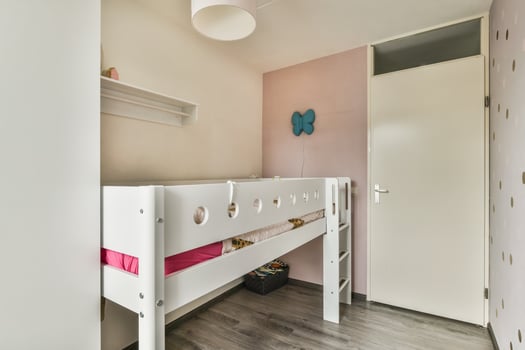 A small bedroom with a bunk bed and pink walls photo
