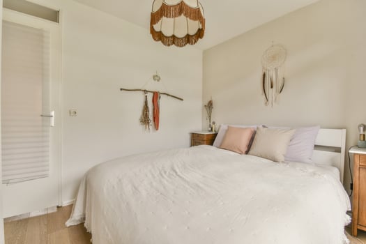 A bedroom with a white bed and wooden floor photo