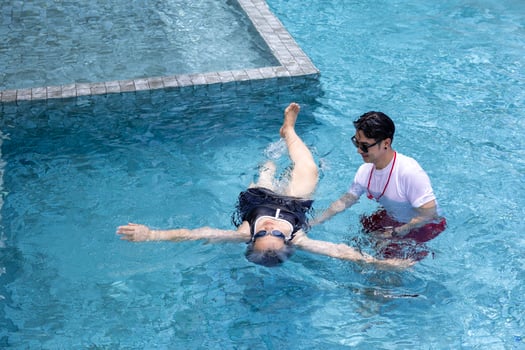 Senior asian woman is learning how to swim at the swimming pool with professional trainer for retirement exercise workout activity and healthy wellbeing photo