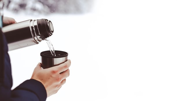 Pouring Hot Drink From Thermos Into Cup photo