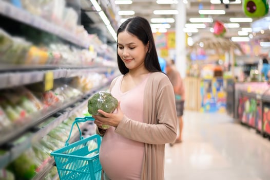 Beautiful pregnant woman shopping healthy food at grocery shop photo