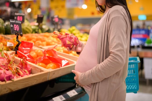 Beautiful pregnant woman shopping healthy food at grocery shop photo