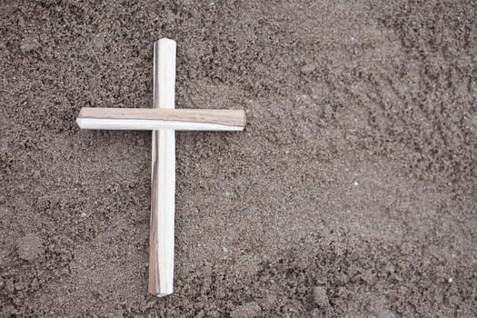 Wooden crucifix on ground. Concept, Christian worship. Faith, forgiveness, belief, love, hope, peace and happiness. Crucifix, religious symbol of Christianity. photo