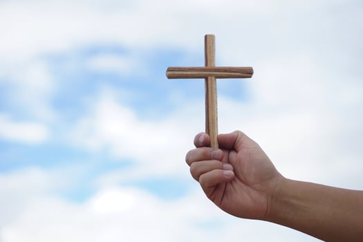 Closeup hand holds wooden cross. Concept, Christian worship. Faith, forgiveness ,belief, love, hope, peace and happiness. Crucifix, religious symbol of Christianity. photo