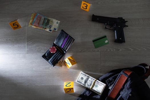Crime scene investigation - numbering of evidences after the murdering in apartment. Brass knuckle, wallet and clothes with evidence markers photo