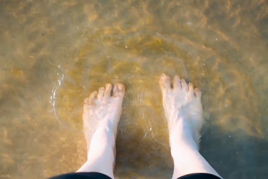 Woman's bare feet walking at a beach. photo