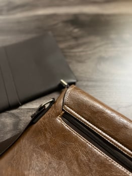 Leather bag with gadgets and notebooks on Wooden Work Desk photo
