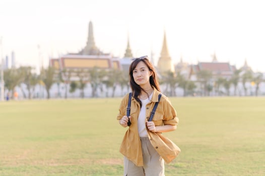 A Traveler Asian woman in her 30s exploring Wat Pra Kaew. From stunning architecture to friendly locals, she cherishes every moment, capturing it all in her heart and camera for years to come. photo