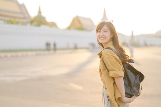 Traveler asian woman in her 30s stands bathed in the golden glow of sunset, embracing the freedom of exploration. on summer holiday weekend vacation trip in Bangkok, Thailand photo