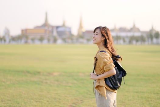 A Traveler Asian woman in her 30s exploring Wat Pra Kaew. From stunning architecture to friendly locals, she cherishes every moment, capturing it all in her heart and camera for years to come. photo