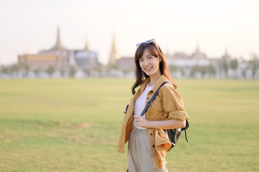 A Traveler Asian woman in her 30s exploring Wat Pra Kaew. From stunning architecture to friendly locals, she cherishes every moment, capturing it all in her heart and camera for years to come. photo