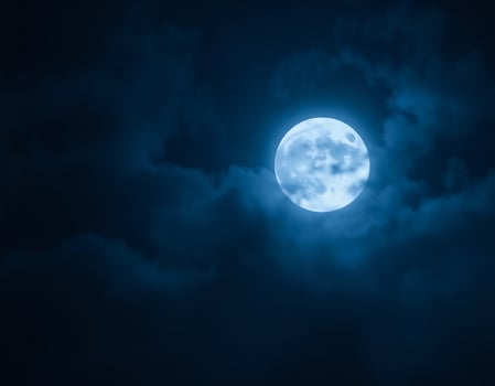 Full moon illuminating a dark, cloudy night sky with dense blue fog. Halloween background , nighttime ambiance, lunar light concept, gothic aesthetic, eerie atmosphere. photo