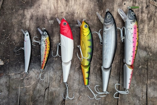 Fishing lures set, spinning ger, angling, sport fishing, catch and release, fish bait isolated on aged wood background photo