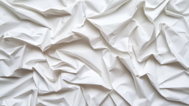 Softly crumpled paper background in light grey tones with subtle creases and folds for an organic texture photo