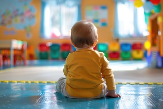 A child sitting on the floor in a classroom photo