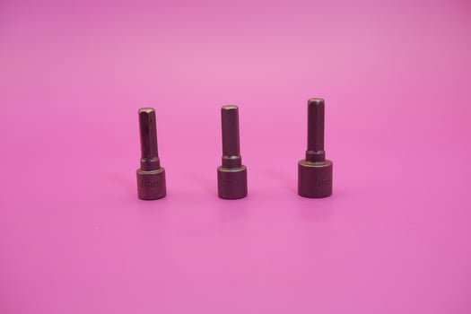 Hexagon screwdriver bit sockets measuring 7 mm, 8 mm, and 10 mm isolated on purple background. photo