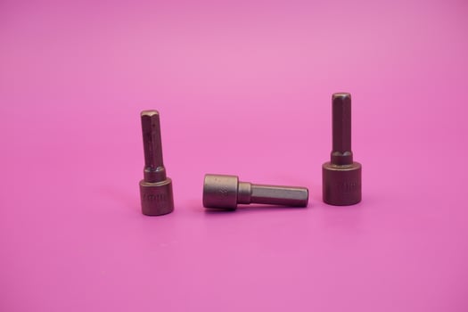 Hexagon screwdriver bit sockets measuring 7 mm, 8 mm, and 10 mm isolated on purple background. photo
