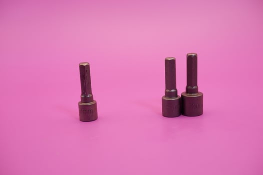 Hexagon screwdriver bit sockets measuring 7 mm, 8 mm, and 10 mm isolated on purple background. photo