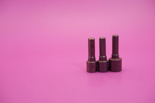 Hexagon screwdriver bit sockets measuring 7 mm, 8 mm, and 10 mm isolated on purple background. photo