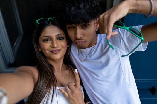 beautiful young teenage couple with funny faces having fun taking a selfie on an a terrace photo