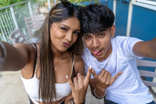 beautiful young teenage couple with funny faces having fun taking a selfie on an a terrace photo