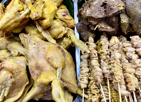 Fried chicken and chicken intestine satay dish on stainless steel food tray. Sate usus and ayam goreng on horizontal background. photo