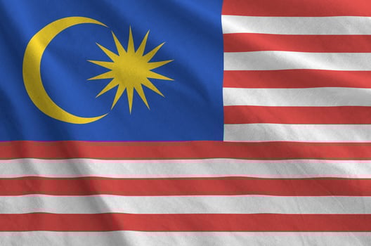 Malaysia flag depicted on folded wavy fabric of old cloth photo