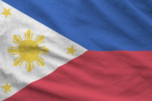 Philippines flag depicted on folded wavy fabric of old cloth photo