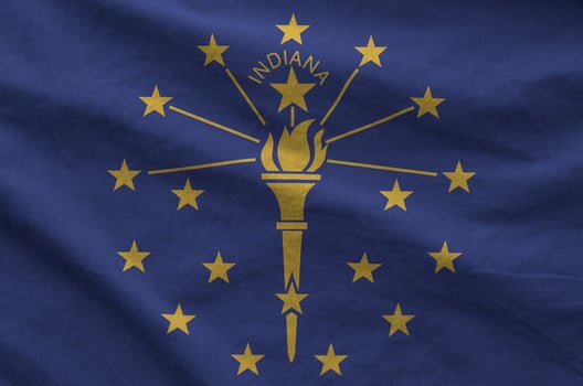 Indiana US state flag depicted on folded wavy fabric of old cloth photo